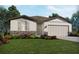 Charming single-Gathering home with stone accents, an attached garage, and a lush, landscaped front yard at 1859 Draughton Dr, Zephyrhills, FL 33541
