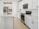 Modern kitchen with white cabinets, stainless steel appliances, and a center island with sink at 1859 Draughton Dr, Zephyrhills, FL 33541