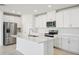 Bright kitchen featuring stainless steel appliances, white cabinetry, and center island at 1859 Draughton Dr, Zephyrhills, FL 33541