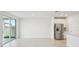 A bright living room with tile flooring and a stainless steel refrigerator with an open floor plan at 1859 Draughton Dr, Zephyrhills, FL 33541