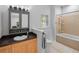 Well-lit bathroom featuring a vanity, toilet, bathtub and shower combination, and a window at 2110 W Farwell Dr, Tampa, FL 33603