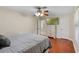 Bedroom with hardwood floors, ceiling fan and a wall mounted television above a dresser at 2110 W Farwell Dr, Tampa, FL 33603