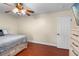 Comfortable bedroom with ceiling fan, wood floors, and a neutral color scheme at 2110 W Farwell Dr, Tampa, FL 33603