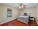 Cozy bedroom featuring wood-look floors, a ceiling fan, and a window with natural light at 2110 W Farwell Dr, Tampa, FL 33603