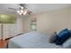 Comfortable bedroom with hardwood floors, a ceiling fan, and a dresser with television, creating a relaxing retreat at 2110 W Farwell Dr, Tampa, FL 33603