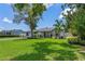 Charming single-story home with a lush green lawn, mature trees, and a quaint covered porch area at 2110 W Farwell Dr, Tampa, FL 33603