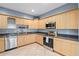 Kitchen features stainless steel appliances, stone countertops, and wood cabinets at 2110 W Farwell Dr, Tampa, FL 33603