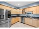 Bright kitchen featuring stainless steel appliances, tile flooring, and light wood cabinets at 2110 W Farwell Dr, Tampa, FL 33603