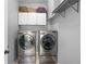 Laundry room featuring front load washer and dryer with cabinets above at 2110 W Farwell Dr, Tampa, FL 33603