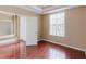 Bedroom with wood-look flooring, large window, and an ensuite bathroom at 2707 Wood Pointe Dr, Holiday, FL 34691