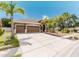 Attractive single-story home featuring a lush front yard, a three-car garage, and a serene, well-maintained landscape at 2707 Wood Pointe Dr, Holiday, FL 34691