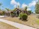 Single-story home showcasing a well-kept front yard with decorative plants, a three-car garage, and a neat landscape at 2707 Wood Pointe Dr, Holiday, FL 34691