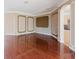 Elegant living room showcasing gleaming hardwood floors and a glimpse into the kitchen and abundant natural light at 2707 Wood Pointe Dr, Holiday, FL 34691