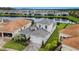 Aerial view showcasing home with a gray tile roof, two car garage, nice landscaping, and community pond view at 32740 Tree Of Life Ave, Wesley Chapel, FL 33543