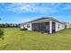 Wide backyard view with lush grass, a screened-in patio, and partial home exterior at 32740 Tree Of Life Ave, Wesley Chapel, FL 33543