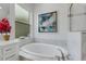 Bathroom features a soaking tub, white cabinets, quartz countertops and picture window at 32740 Tree Of Life Ave, Wesley Chapel, FL 33543