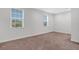 Bright bedroom with two windows offers natural light and comfortable carpet flooring at 32740 Tree Of Life Ave, Wesley Chapel, FL 33543