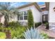 Inviting front entrance with a well-manicured garden, decorative stone accents, and a modern black front door at 32740 Tree Of Life Ave, Wesley Chapel, FL 33543