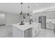 Kitchen with white cabinets, stainless appliances, large center island, and tiled flooring at 32740 Tree Of Life Ave, Wesley Chapel, FL 33543