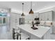Bright kitchen features white cabinets, stainless appliances, large island with pendant lights at 32740 Tree Of Life Ave, Wesley Chapel, FL 33543