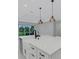 Close up of kitchen island with a white countertop and modern pendant lights at 32740 Tree Of Life Ave, Wesley Chapel, FL 33543