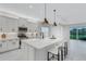 Modern white kitchen with a large island, stainless steel appliances, and pendant lighting at 32740 Tree Of Life Ave, Wesley Chapel, FL 33543
