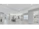 Spacious living room showcasing an open floor plan, and modern kitchen with white cabinets at 32740 Tree Of Life Ave, Wesley Chapel, FL 33543