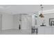 Open floor plan features kitchen with stainless appliances and staircase with white railing at 32740 Tree Of Life Ave, Wesley Chapel, FL 33543
