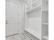Bright mudroom with built-in storage, shelving, bench, and a white door at 32740 Tree Of Life Ave, Wesley Chapel, FL 33543