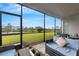 Screened-in patio with wicker furniture and views of pond and green space at 32740 Tree Of Life Ave, Wesley Chapel, FL 33543