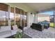 Covered outdoor patio with stylish wicker furniture and brick-paved flooring at 32740 Tree Of Life Ave, Wesley Chapel, FL 33543