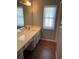 Bathroom with a vanity, sink, and ample counter space, complemented by wood flooring at 420 S Brockfield Dr, Sun City Center, FL 33573