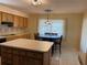 Kitchen and dining area featuring a center island, dark wood table, and modern light fixtures at 420 S Brockfield Dr, Sun City Center, FL 33573