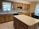 Kitchen with wooden cabinets, light countertops, an island, and updated backsplash at 420 S Brockfield Dr, Sun City Center, FL 33573