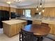 Kitchen featuring wood cabinets, an island, modern lighting fixtures and stainless steel appliances at 420 S Brockfield Dr, Sun City Center, FL 33573