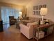 Bright living room featuring hardwood floors, modern sofa, and draped windows at 420 S Brockfield Dr, Sun City Center, FL 33573