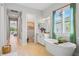 Bathroom featuring a soaking tub under a window, leading to a bedroom and hallway at 4754 Manning Ct, Sarasota, FL 34240