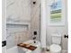 Stylish bathroom featuring marble-look tile, a tub with shower, and a decorative niche at 4754 Manning Ct, Sarasota, FL 34240