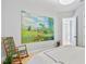 Bedroom featuring a landscape painting, rocking chair, and view into the hall at 4754 Manning Ct, Sarasota, FL 34240