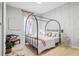 Charming bedroom featuring a black canopy bed, wood floors, and soft natural light at 4754 Manning Ct, Sarasota, FL 34240