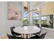Dining area with modern lighting fixture, round table, and view of the screened-in patio and pond at 4754 Manning Ct, Sarasota, FL 34240