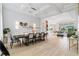 Open-concept dining room boasts wood-look tile floors, wainscotting, and an elegant, modern light fixture at 4754 Manning Ct, Sarasota, FL 34240