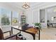 Home office featuring plantation shutters, a work desk, modern light fixture and view to dining room at 4754 Manning Ct, Sarasota, FL 34240