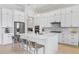 Bright kitchen with white cabinetry, stainless steel appliances, an island with seating, and stylish backsplash at 4754 Manning Ct, Sarasota, FL 34240