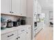 Bright kitchen featuring white cabinets, quartz countertops, mosaic backsplash, and stainless steel appliances at 4754 Manning Ct, Sarasota, FL 34240