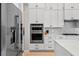 Close-up of a stainless steel refrigerator and double ovens in a modern kitchen with white cabinetry at 4754 Manning Ct, Sarasota, FL 34240
