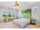 Light-filled main bedroom with a large window, light wood floors, and artistic decor at 4754 Manning Ct, Sarasota, FL 34240