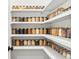 Organized pantry with white shelves stocked with jars of dry goods at 4754 Manning Ct, Sarasota, FL 34240