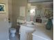 Bright bathroom features a vanity, toilet, and shower, with neutral finishes at 4875 Hansard Ave, North Port, FL 34286
