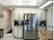 Bright kitchen featuring stainless steel refrigerator, granite countertops, and classic cabinetry at 4875 Hansard Ave, North Port, FL 34286